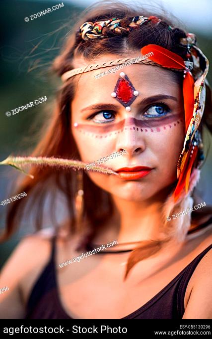 Portrait of a beautiful ethnic woman posing outdoor. Creative makeup