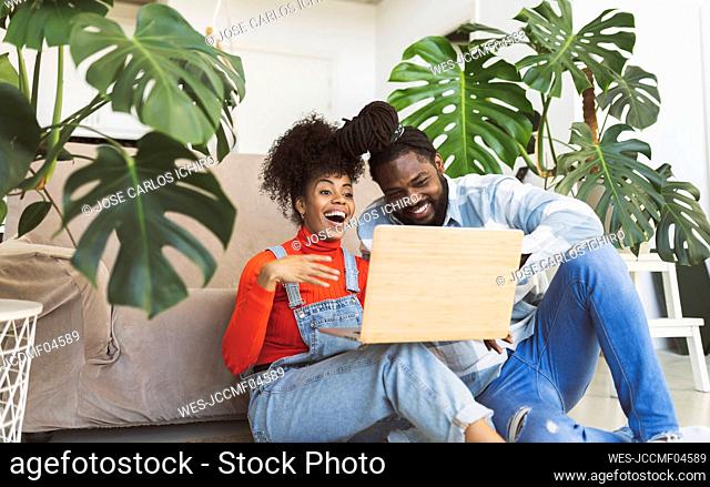 Happy couple on video call through laptop at home