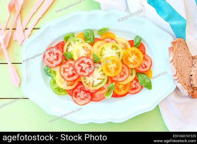 Gruene, gelbe und rote Tomaten als bunter Salat