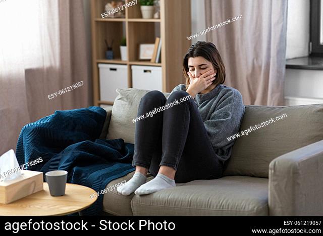 stressed woman sitting on sofa at home