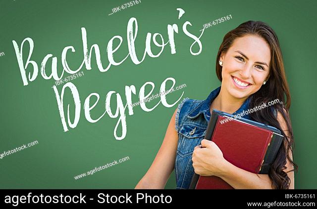 Bachelors degree written on chalk board behind mixed-race young girl student holding books