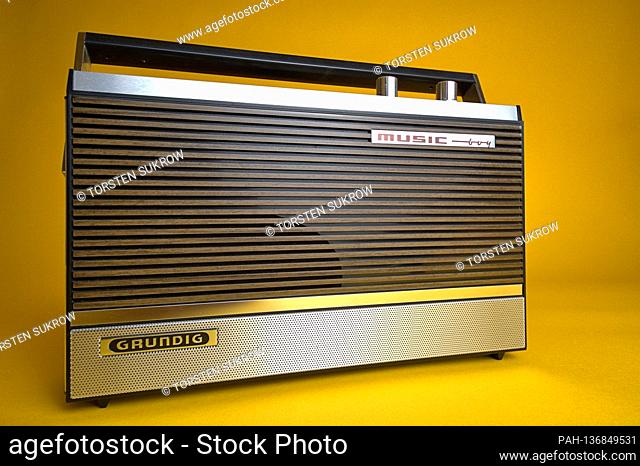 An old portable radio made by Grundig, type Music-Boy 209, which was built and sold from 1969 to 1970. Photo against a vintage 1970s style background