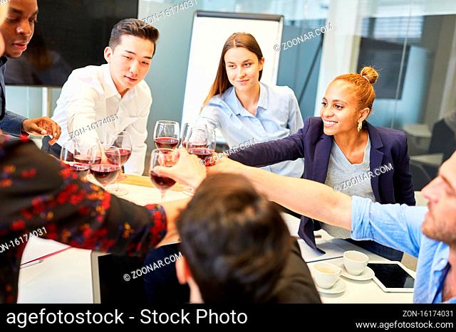 Gruppe Geschäftsleute feiert mit Rotwein auf einer Betriebsfeier nach einem Erfolg