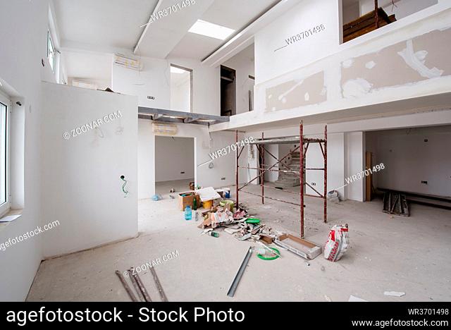 interior of construction site with scaffolding in a large modern unfinished duplex apartment