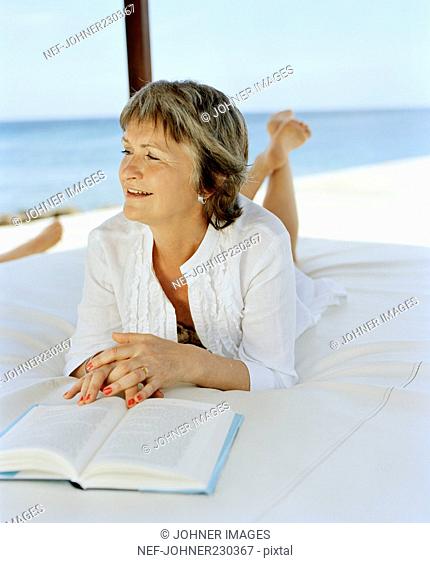 Woman lying on a bed and reading
