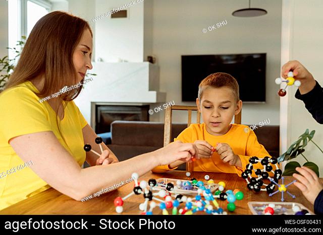 Mother teaching boy about molecules at home