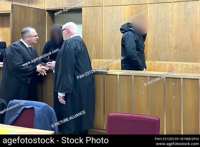 05 December 2023, Lower Saxony, Hanover: The accused mother (2nd from left) speaks with her defense lawyers while her accused partner (r) enters the courtroom...