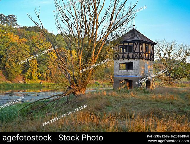 12 September 2023, Brandenburg, Brieskow-Finkenheerd: In the light of sunrise, the former finish judges' tower stands on the shore of Lake Brieskow