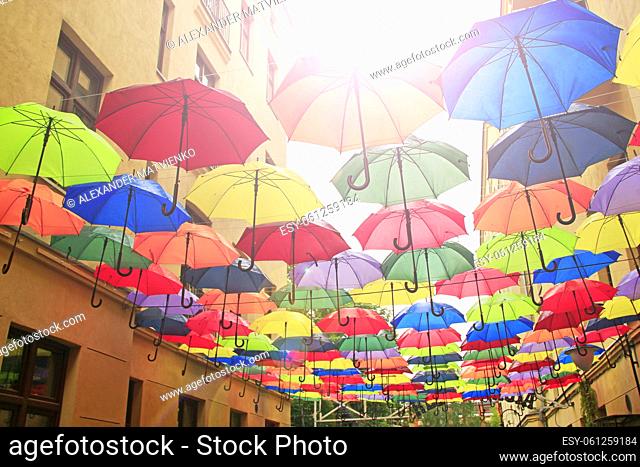 Colored umbrellas hanging at top. Set of different umbrellas. Local landmark. Cafe decoration in Lodz. Multicolored umbrella. Street decoration
