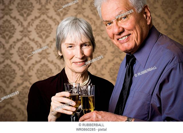 Portrait of an elderly couple holding glasses of wine