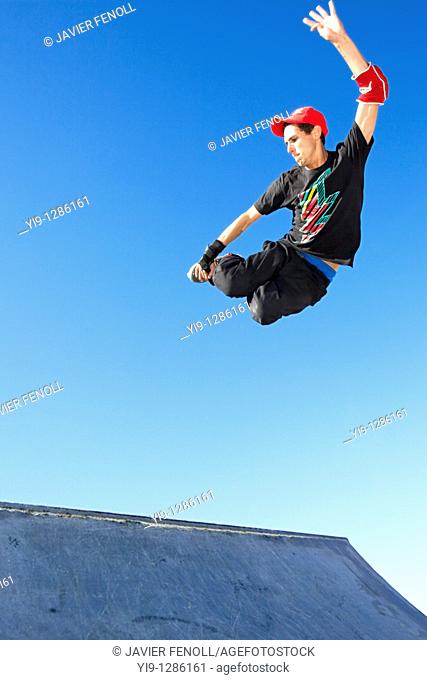 Young man jumping in mid air wearing inline skates