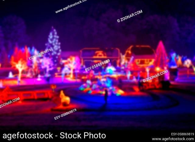 Trees and houses in christmas lights blurred view on beautiful snowy winter night