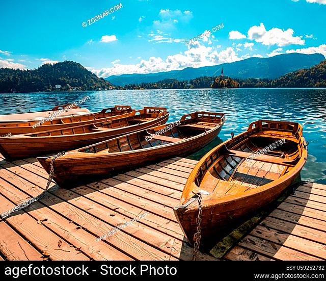 Traditional wooden boats Pletna on the backgorund of Church on the Island on Lake Bled, Slovenia. Europe in summer