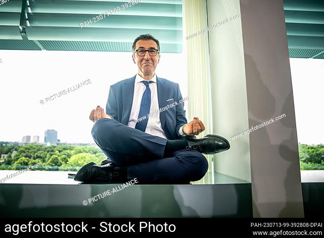 dpatop - 13 July 2023, Berlin: Cem Özdemir (Bündnis 90/Die Grünen), Federal Minister of Food and Agriculture, sits on the windowsill before the start of the...