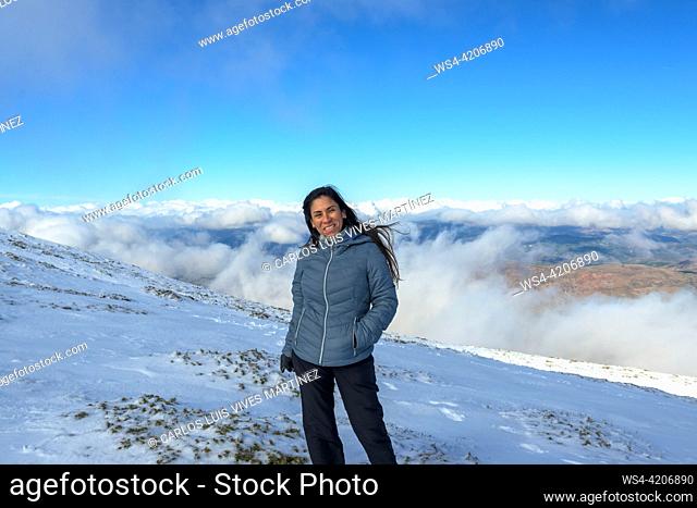 portrait of latina woman in the snow above the clouds