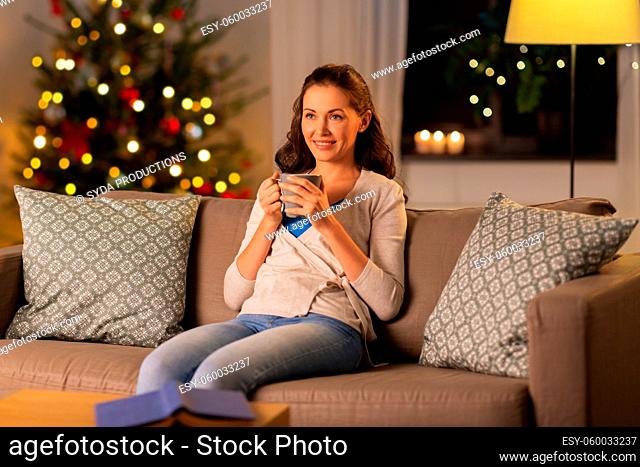 happy woman drinking tea or coffee on christmas