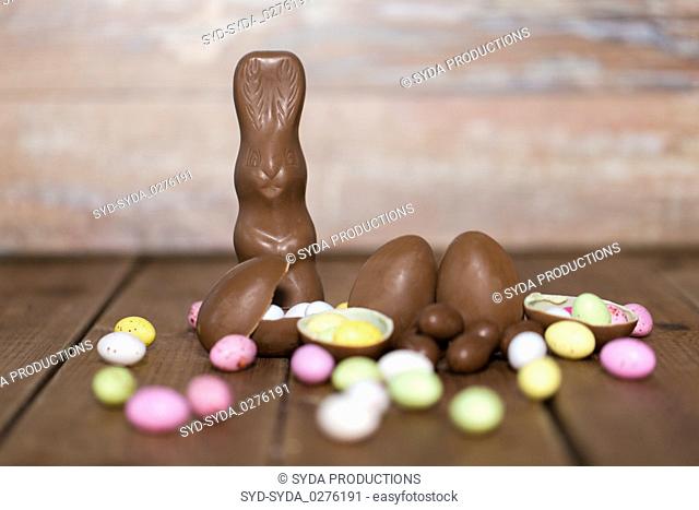 chocolate eggs, easter bunny and candies on wood