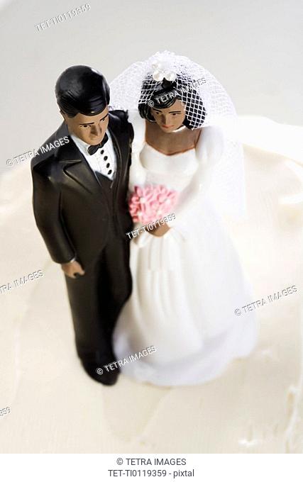 Bride and groom on top of wedding cake