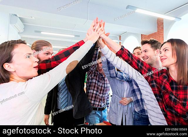 Business people in casual clothes giving high five in the office