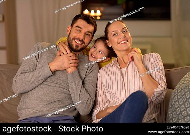 portrait of happy family sitting on sofa at home