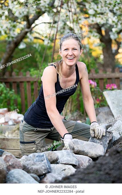 Smiling woman working in garden