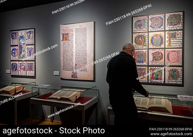 18 January 2023, Rhineland-Palatinate, Trier: A man looks at a volume of the ""Maximin Giant Bible, "" which is on permanent loan to the Trier Treasury