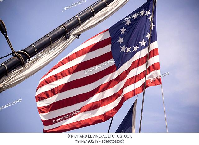 The American flag with thirteen stars representing the thirteen colonies flies from the French frigate L'Hermione berthed on the East River in New York