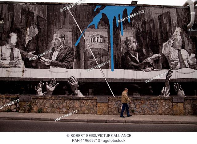 Greek man in front of mural ""The Supper with Greek politicians and the Acropolis"" in the center of Athens. 25.04.2019 | usage worldwide