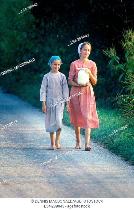 Amish girls taking fresh milk to sell at neighbors house