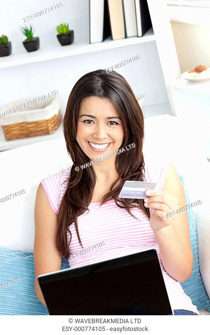 Happy young woman is using a laptop at home
