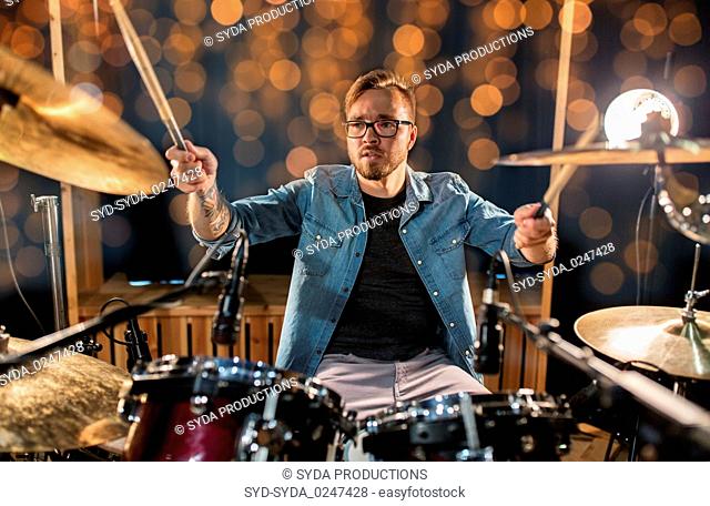 musician or drummer playing drum kit at concert
