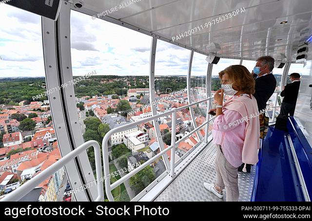 11 July 2020, Thuringia, Weimar: Guests of the premiere ride look out over the city from the approximately 80-metre-high mobile viewing platform ""City...