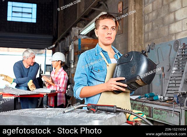Junge Frau als Lehrling zum Schweißer im Betrieb einer Metallverarbeitung