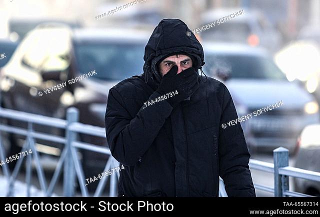 RUSSIA, OMSK - DECEMBER 8, 2023: A man walks in a street in the Siberian city of Omsk on a frosty winter day. According to Russia's weather forecasting agency