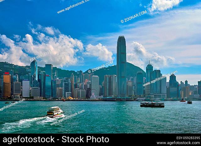 HONG KONG, CHINA - MAY 1, 2018: Boat in Victoria Harbour and Hong Kong skyline cityscape downtown skyscrapers over in the day time with clouds