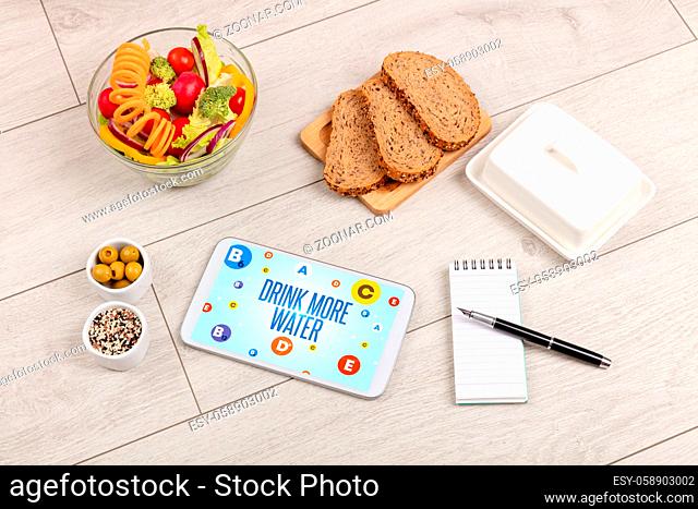 Healthy Tablet Pc compostion with DRINK MORE WATER inscription, weight loss concept