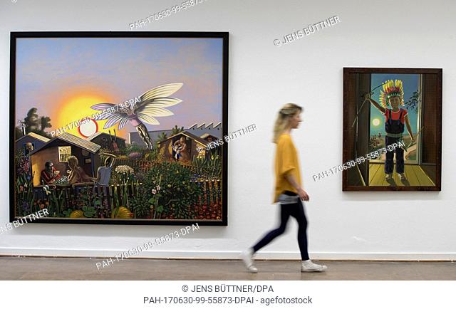 An employee walks past the paintings 'Richard, der Indianer' (r) and 'Der Nacbhar, der will fliegen' (lit. 'The neighbour, he wants to fly', 1983