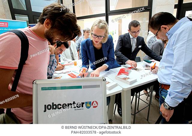 Ulrike Nennhaus and Basher Akeal from the Schwerin employment office helps people fill out forms at the first job training fair for refugees at the Chamber of...
