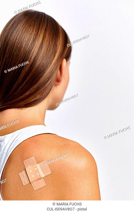 Woman with plaster on back of right shoulder