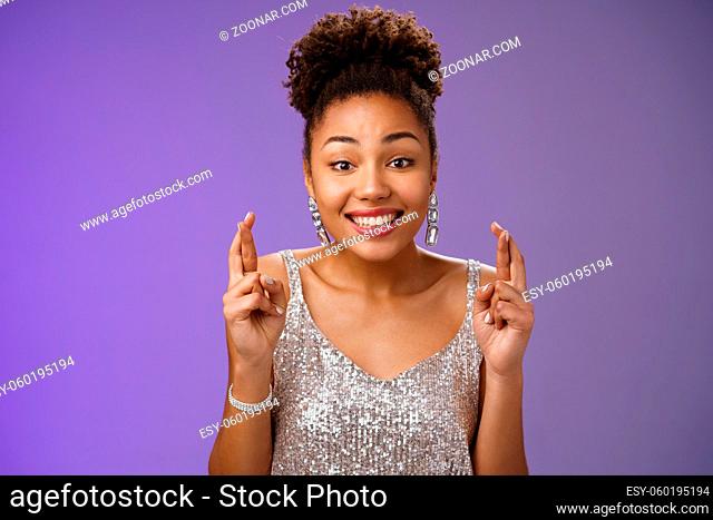 Cheerful optimistic charming african american girlfriend. supporting friend make wish wanna win first prize cross fingers luck smiling broadly wear glittering...