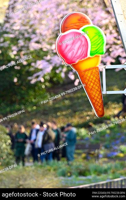 29 March 2022, Hamburg: An advertising sign in the shape of an ice cream cone hangs on an ice cream parlor in Planten un Blomen park