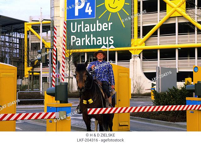 Europe, Germany, North Rhine-Westphalia, Duesseldorf, a man on the horse in front of the airport parking garage, Park and Ride