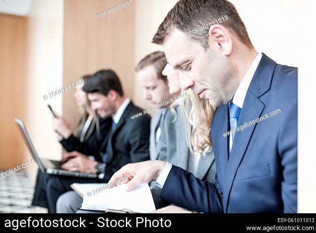 Applicants preparing for employment interview sitting on chairs in queue row line waiting, job hunting concept