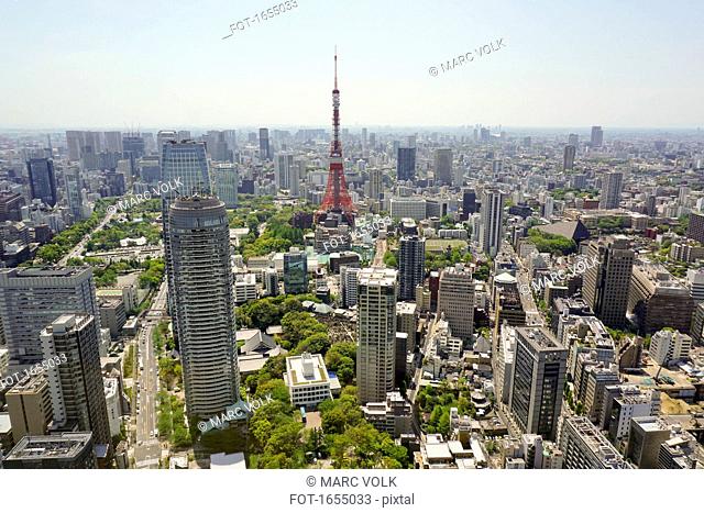 Aerial view of Tokyo Tower in city against sky on sunny day, Tokyo, Japan