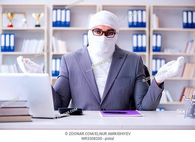 Bandaged businessman worker working in the office doing paperwork