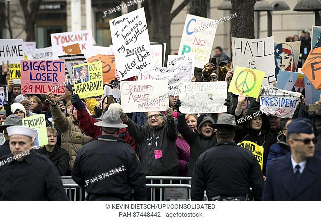 Protesters demonstrate as President Donald Trump and First Lady Melania Trump walk in their inaugural parade after being sworn-in as the 45th President in...