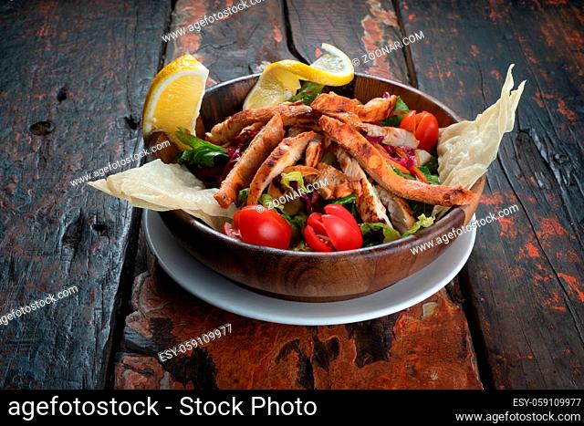 Healthy chicken salad with red cabagge and carrot isolated on rustic wooden kitchen table