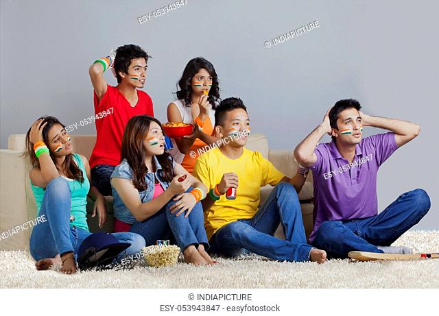 Young friends reacting with disappointment while watching cricket match
