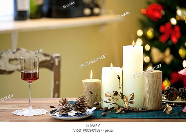 Christmas Candle And Wineglass On Table In Front Of Decorative Christmas Tree