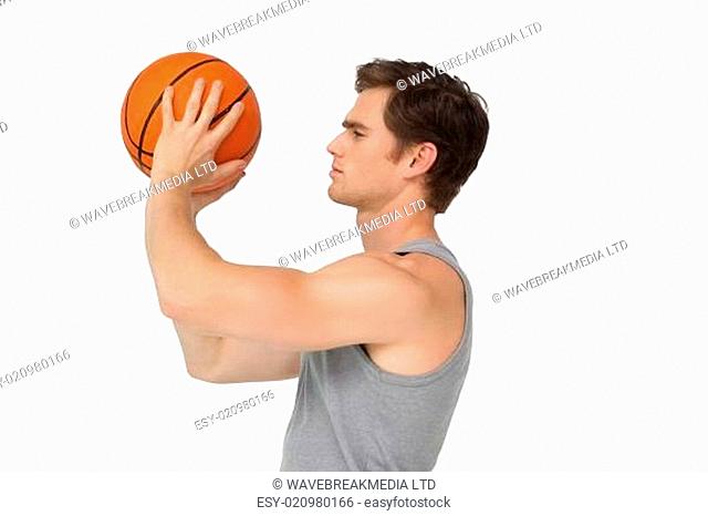 Athletic man holding basketball about to shoot